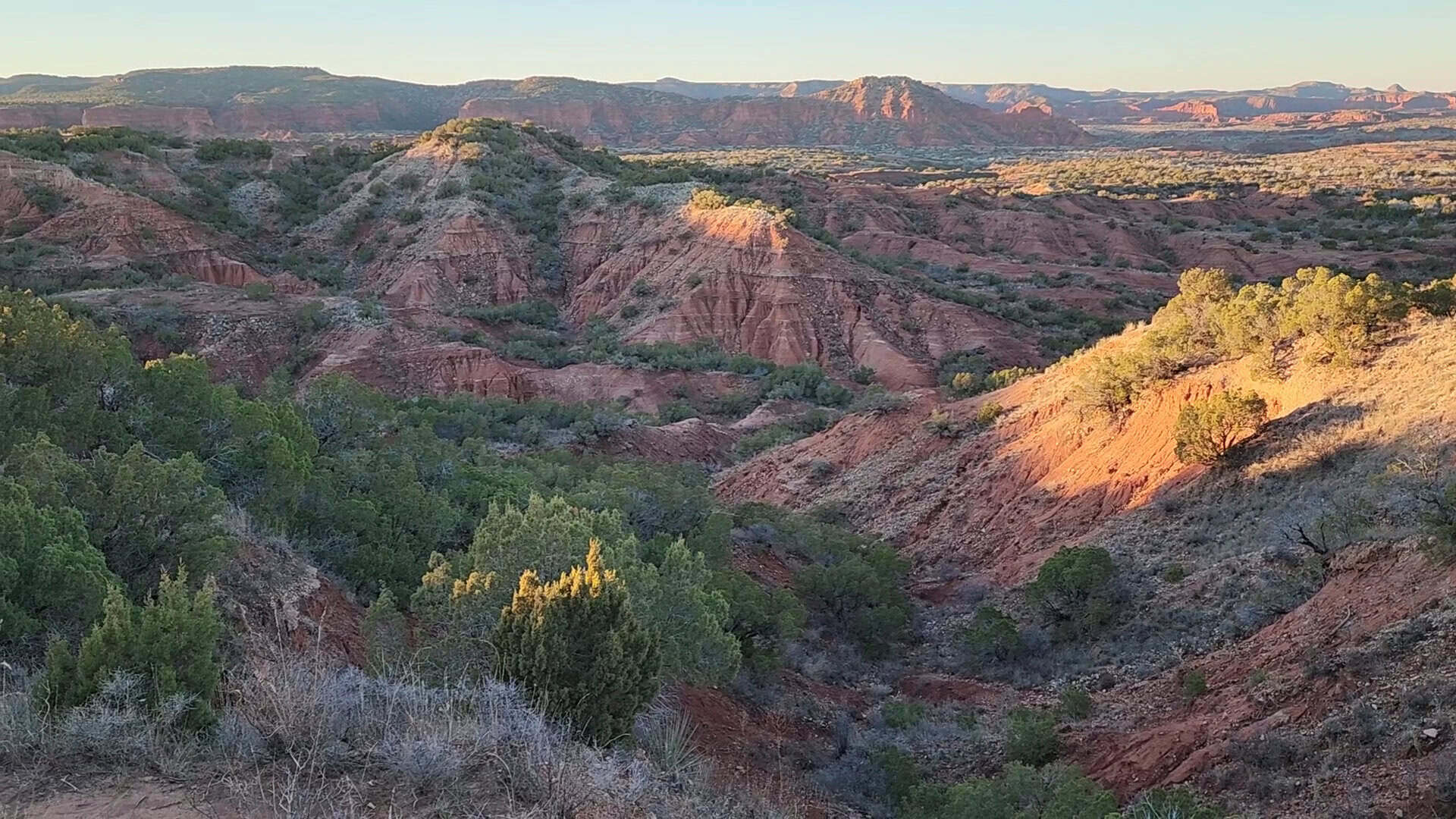 Red rock canyons glowing at sunset in Caprock Canyons State Park, Texas