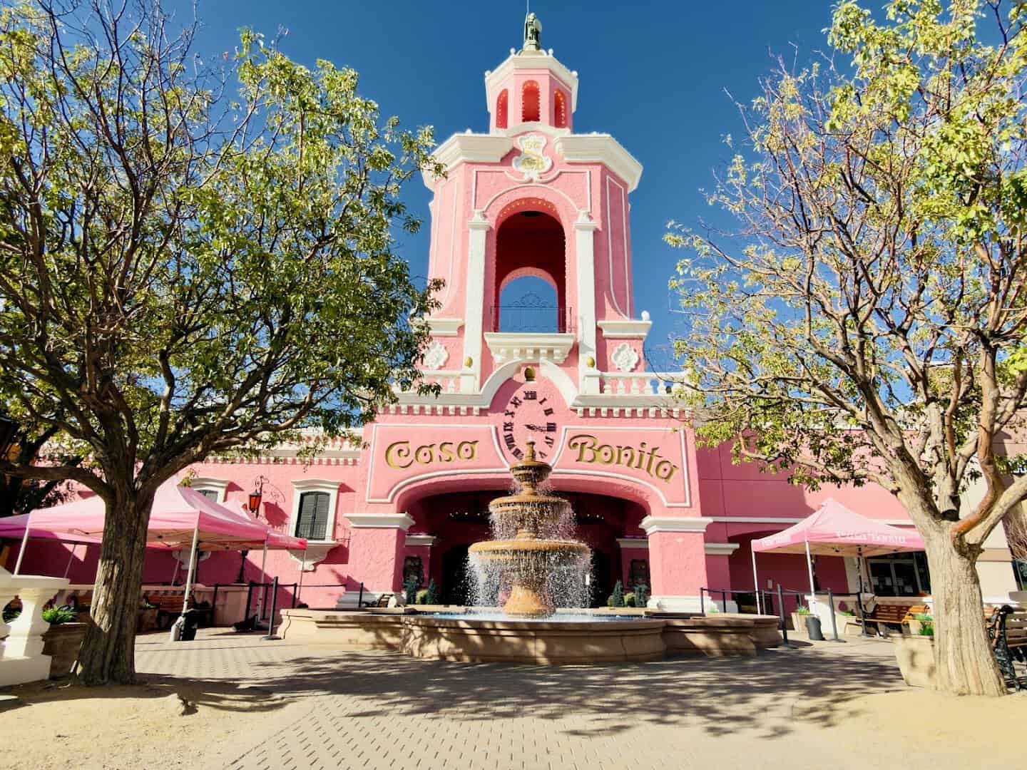 Pink castle exterior and fountain at Casa Bonita in Lakewood, Colorado