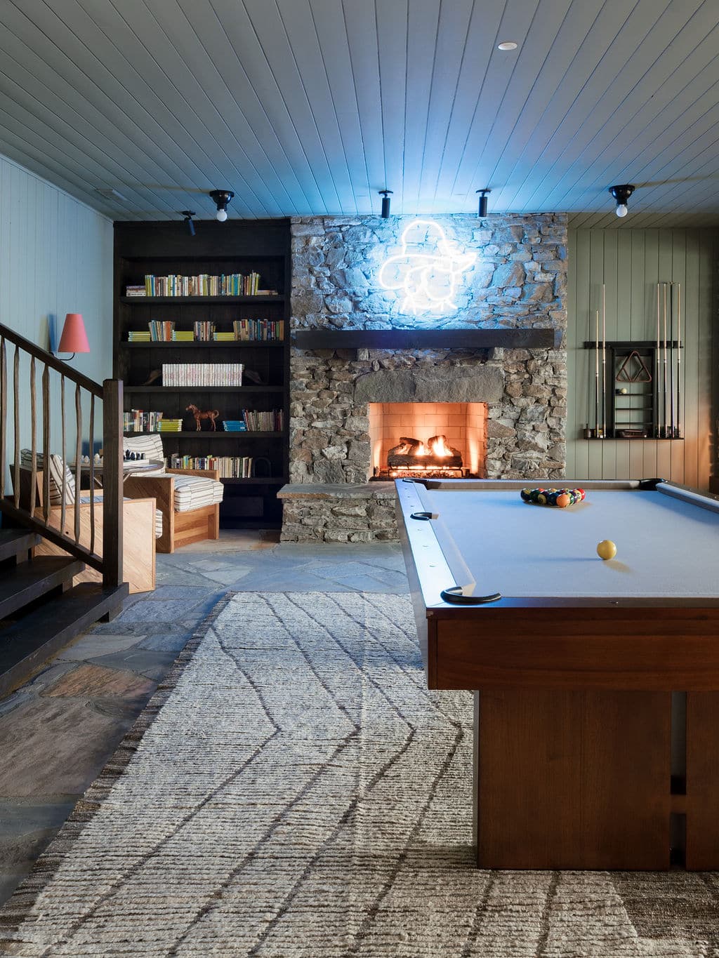 Cozy lodge interior with a stone fireplace and pool table at Cataloochee Ranch in Maggie Valley, North Carolina