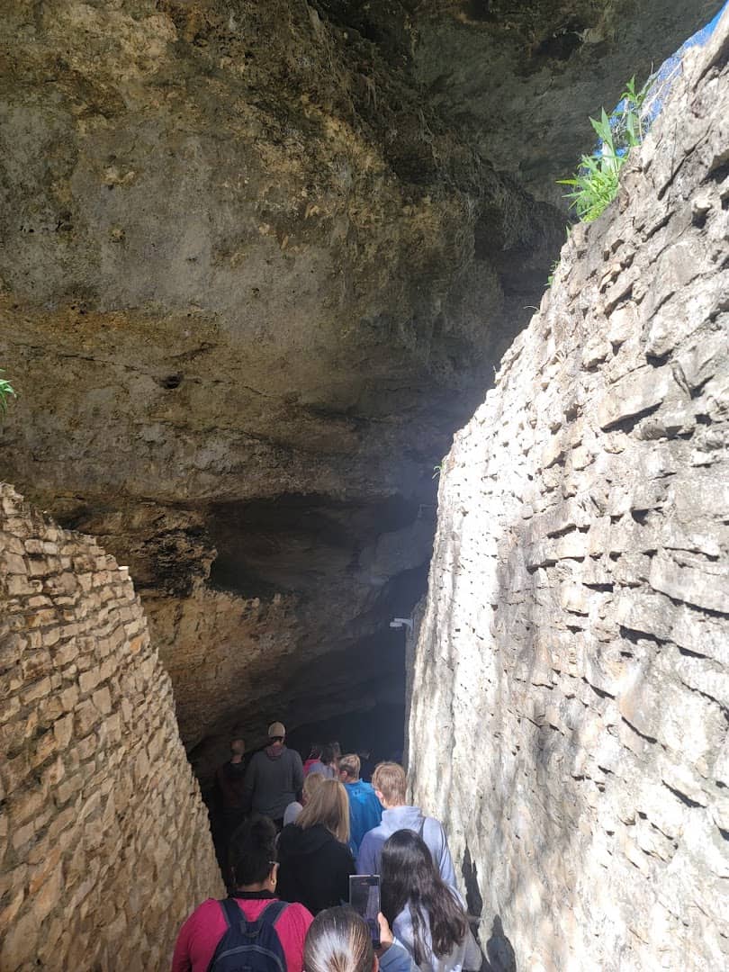 Visitors making their way through a rugged passage in Natural Bridge Caverns