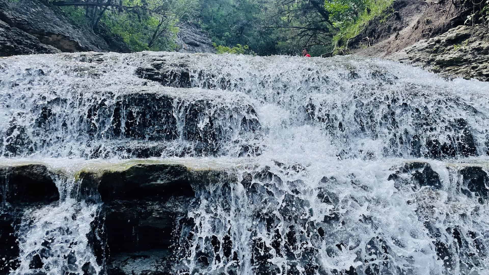 Waterfall spilling over limestone shelves at Chalk Ridge Falls Park near Belton, Texas