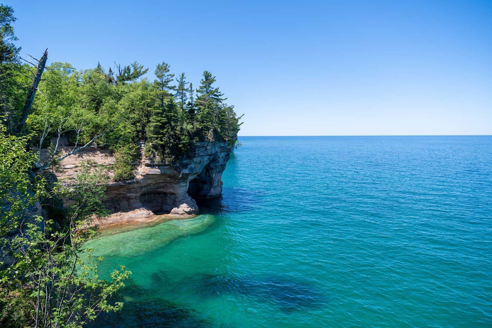 Turquoise cove beneath sandstone cliffs at Chapel Beach, Pictured Rocks, Michigan