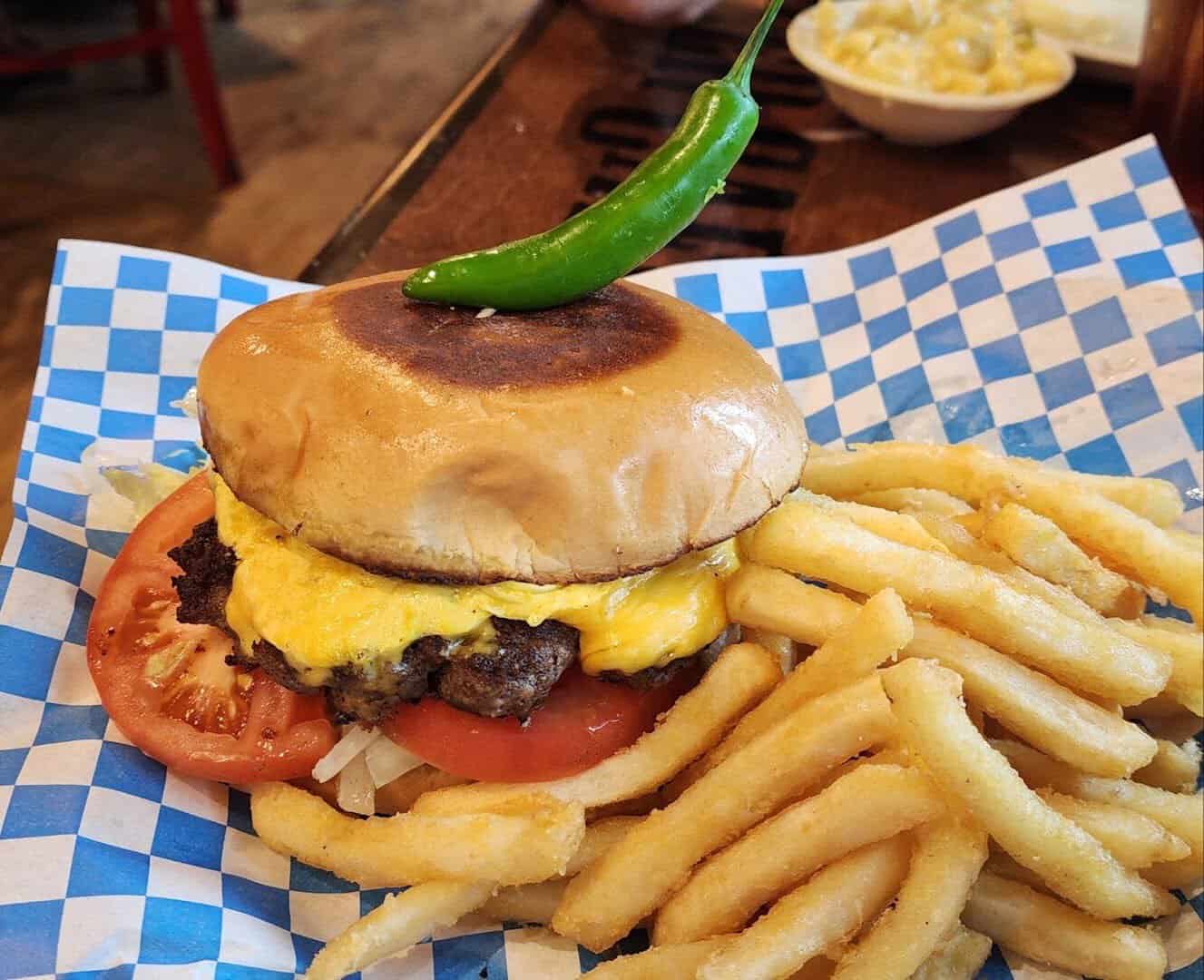Cheeseburger topped with a serrano pepper served with crinkle cut fries at Richter's Antler Cafe in Spring Branch, Texas