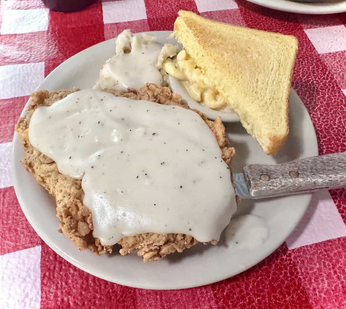 Chicken fried steak smothered in cream gravy with cornbread at Texan Cafe and Pie Shop in Hutto, Texas