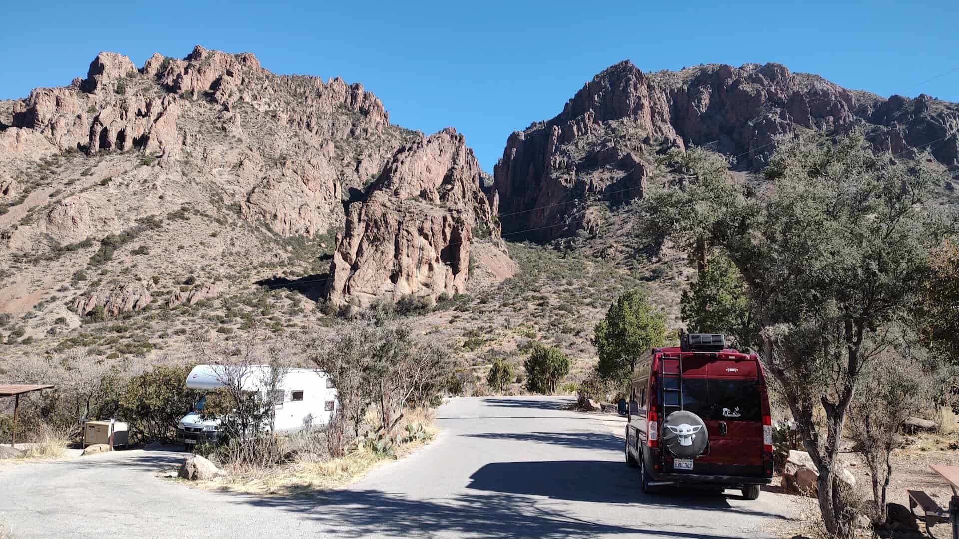 The campground loop road at Chisos Basin with RVs parked below rock walls