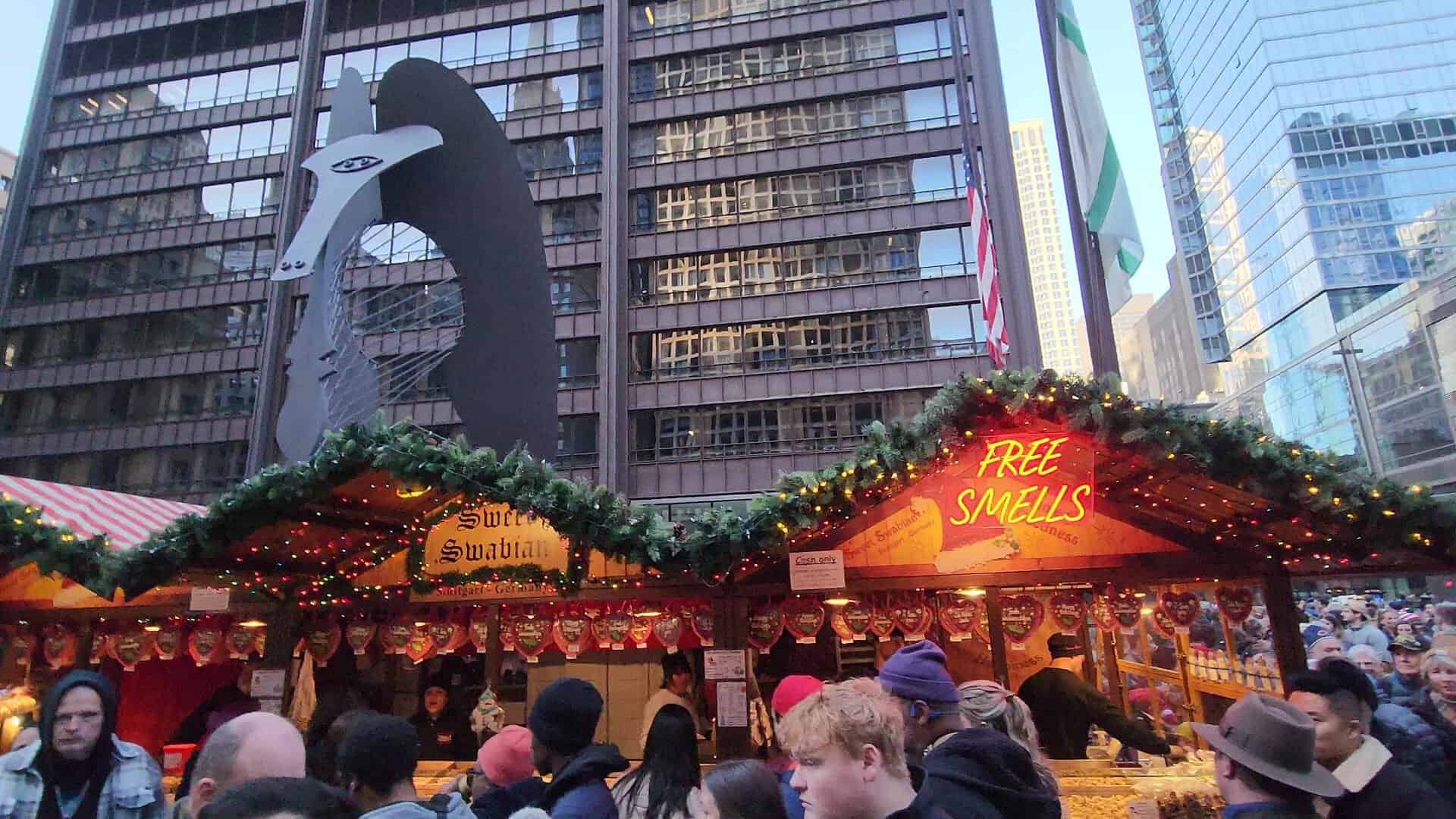 Lit market hut and festive crowd at Christkindlmarket in Chicago, Illinois