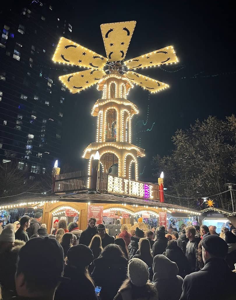 Lit German Christmas pyramid over market huts at Christmas Village in Baltimore, Maryland