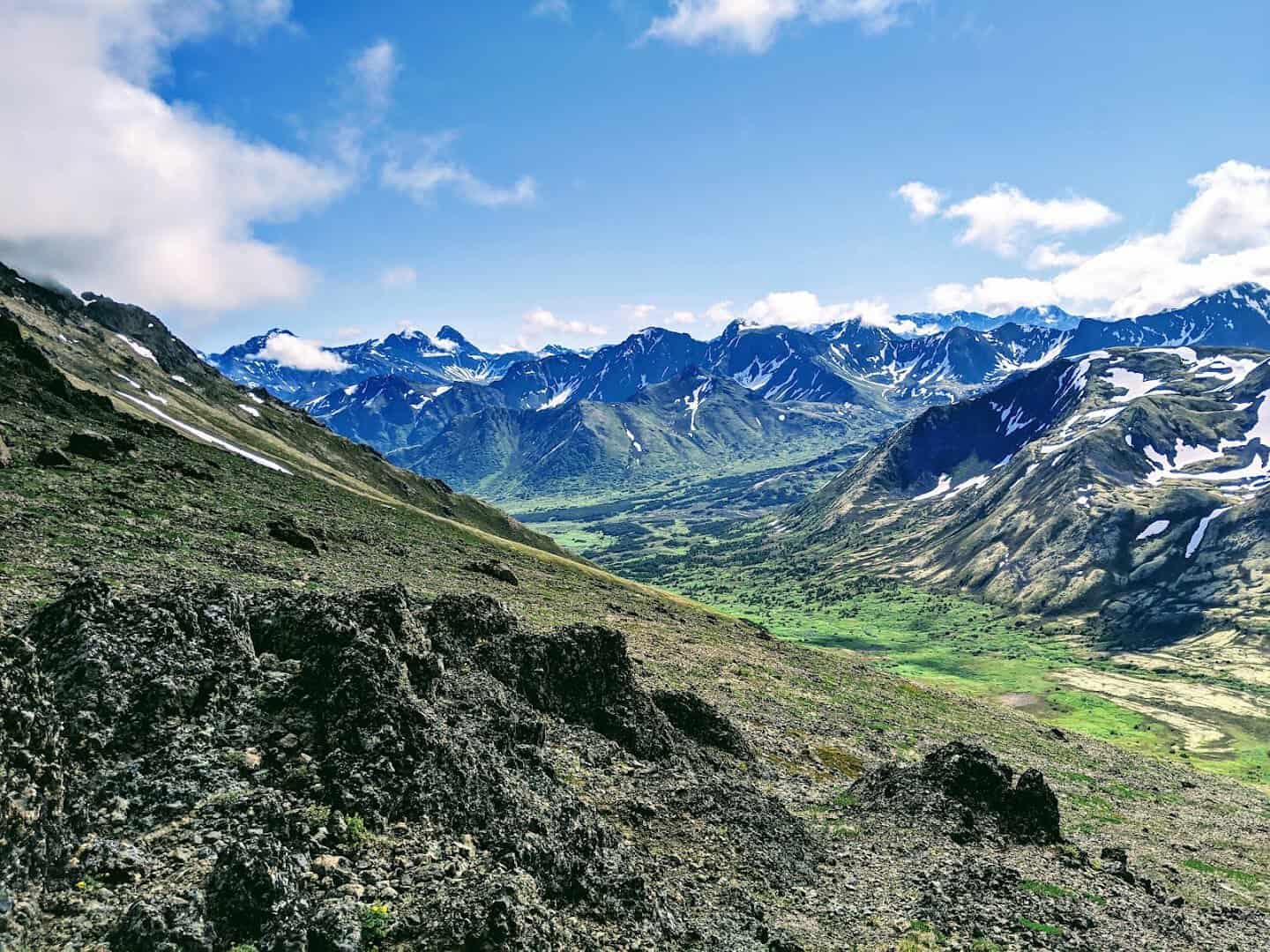 Snow-capped mountains above a green valley in Chugach State Park, Alaska