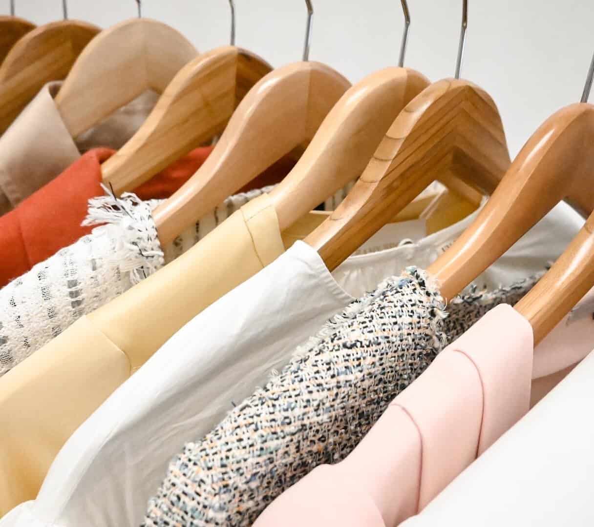 Designer clothing hanging on wooden hangers at Clotheshorse Anonymous in Dallas