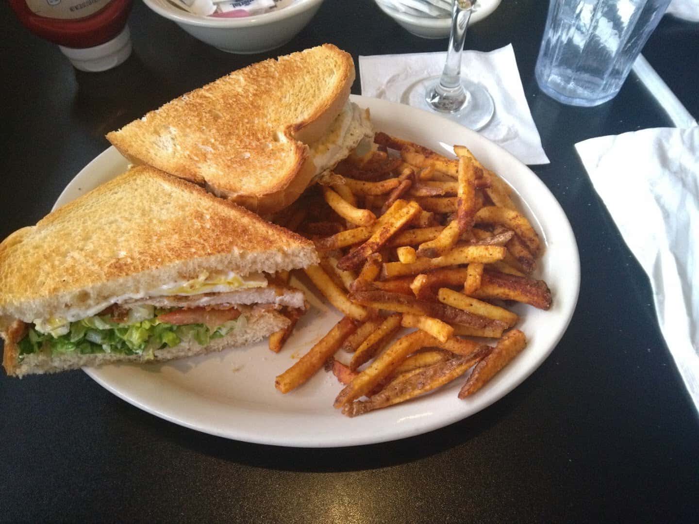 Club sandwich with seasoned fries at Jonathon's Diner in Dallas