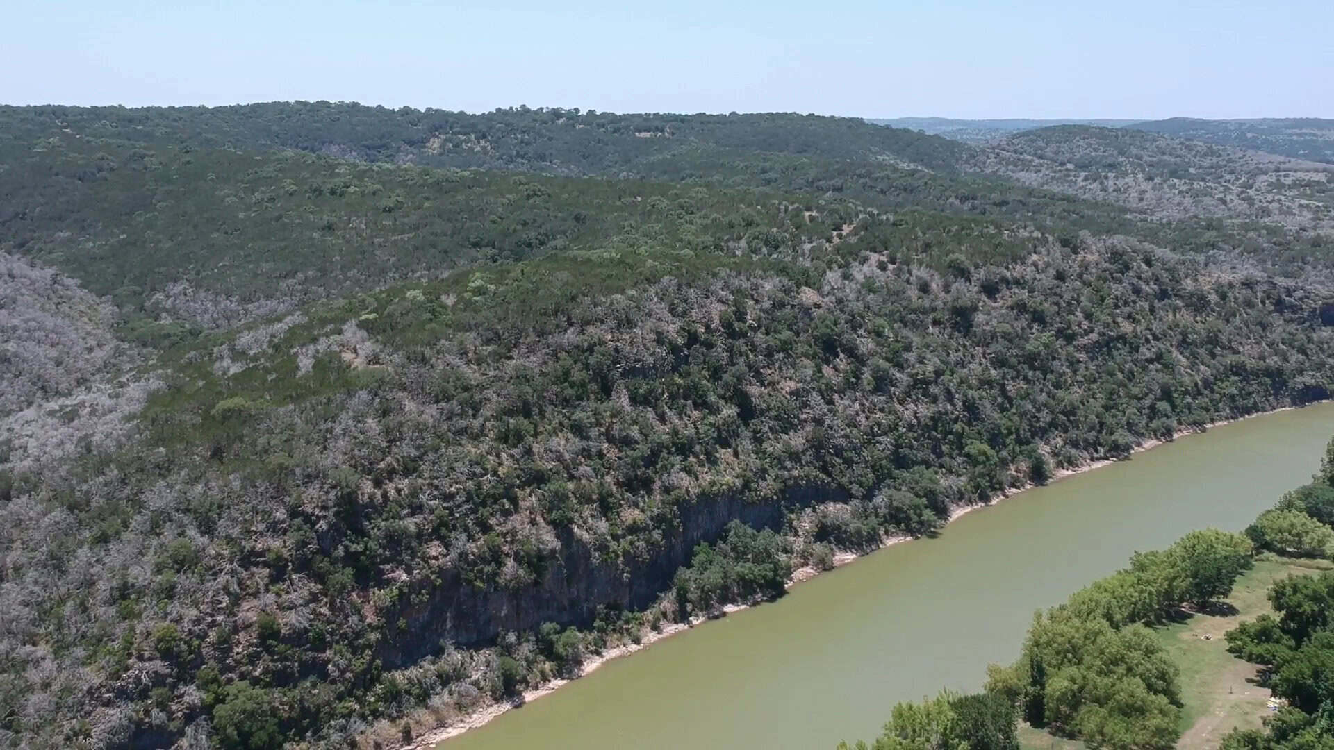 The green Colorado River curling below limestone bluffs at Colorado Bend State Park