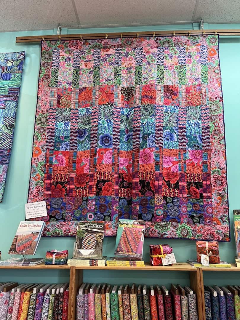 Bright designer quilting fabrics on the shelves at Quilt Country in Lewisville, Texas