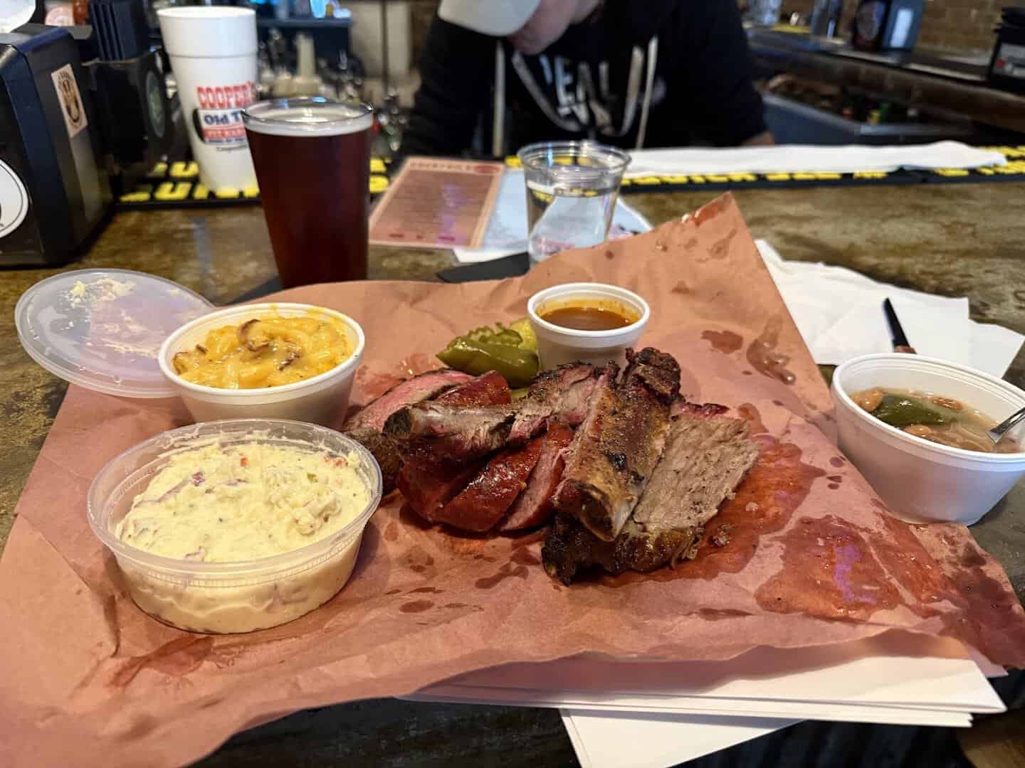 Sliced smoked brisket with mac and cheese and potato salad on a tray at Cooper's Old Time Pit Bar-B-Que in Austin