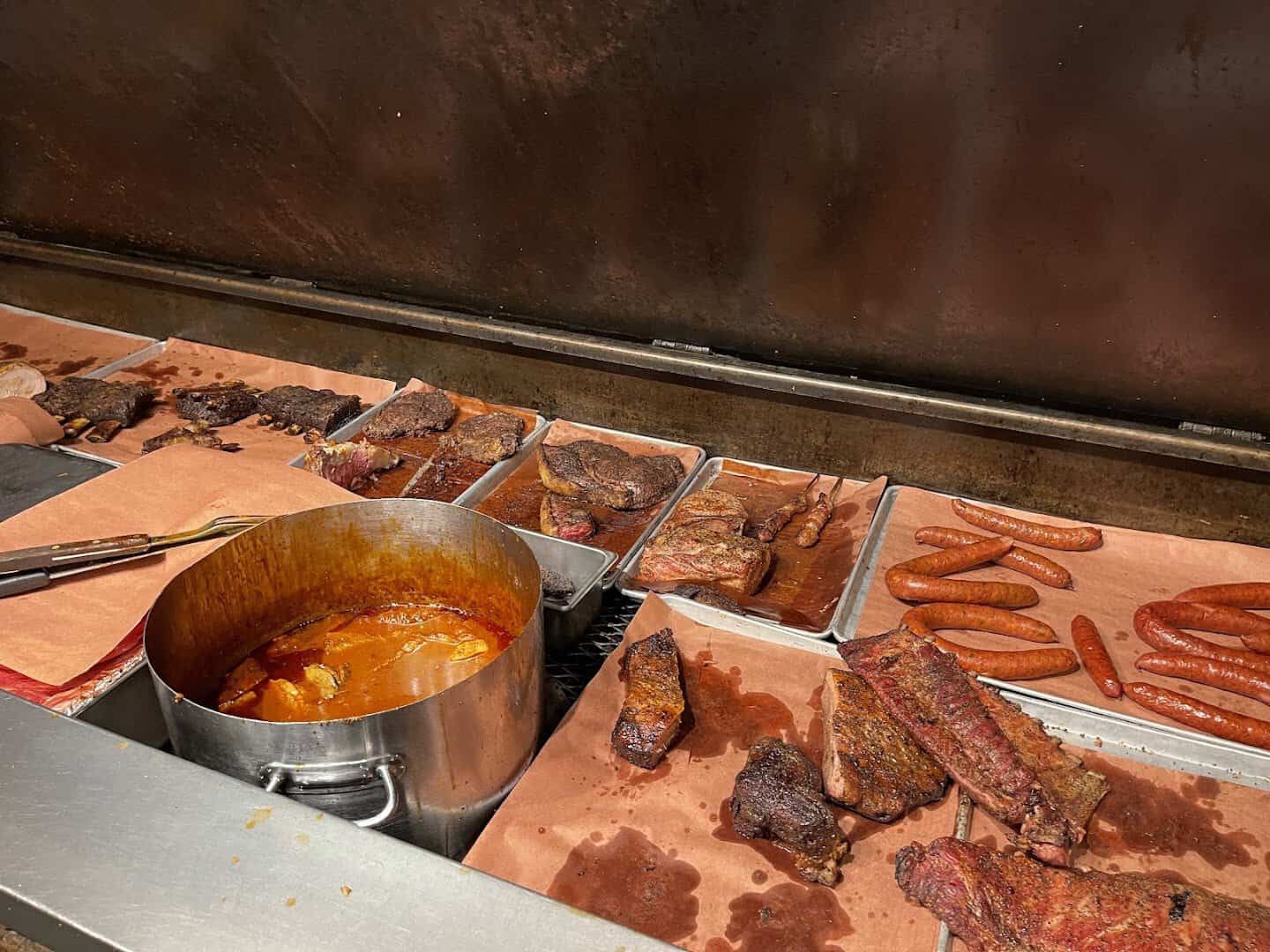 Direct-heat pit lined with smoked steaks, ribs and sausage at Cooper's Old Time Pit Bar-B-Que in Austin