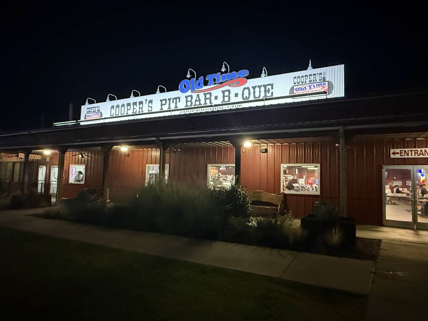 Cooper's Old Time Pit Bar-B-Que storefront lit up at night in the Fort Worth Stockyards