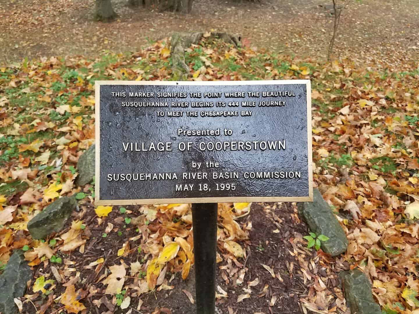 Fallen autumn leaves at the Village of Cooperstown marker in Cooperstown, New York