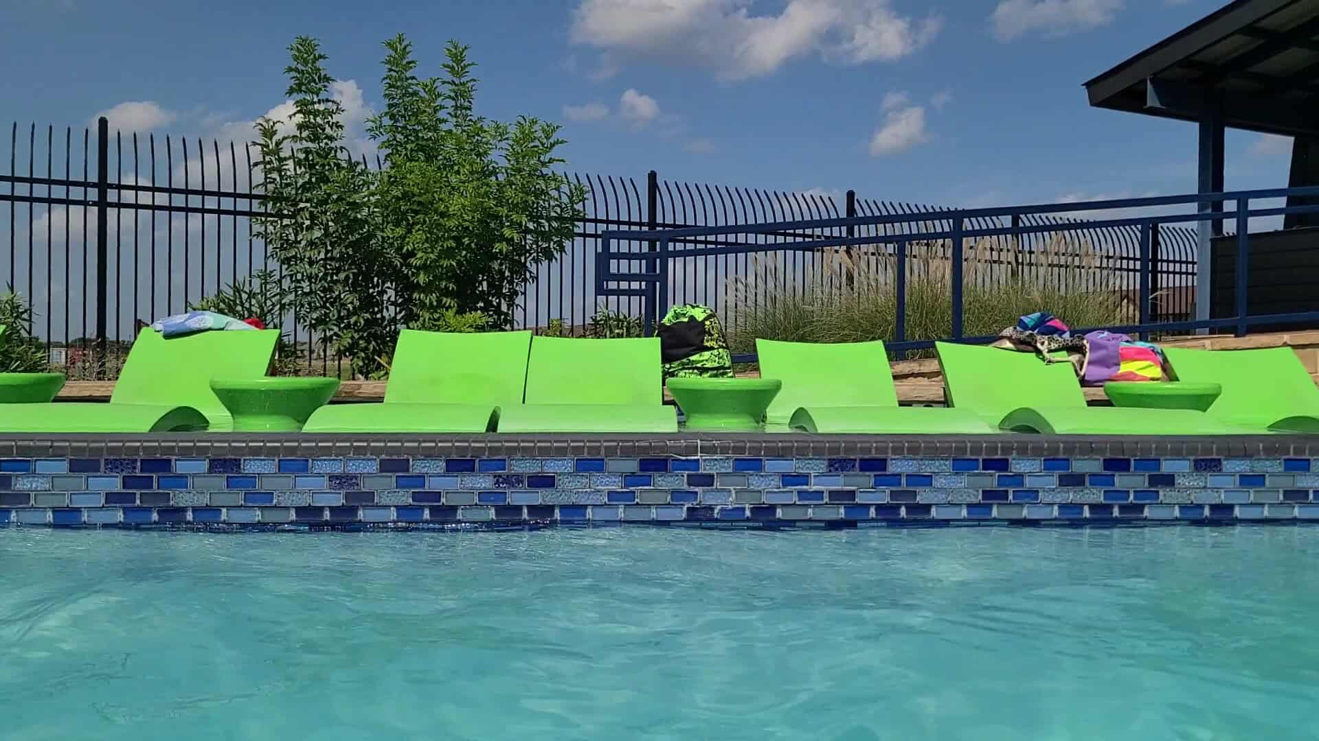 Green aqua loungers lining the pool at The Cove at BearX in College Station, Texas