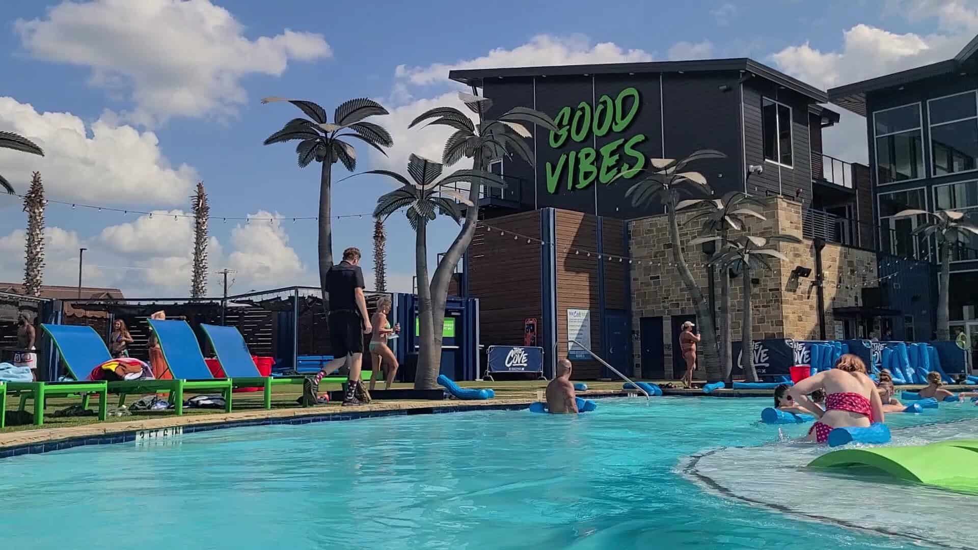 Poolside Good Vibes sign and palms at The Cove at BearX in College Station, Texas