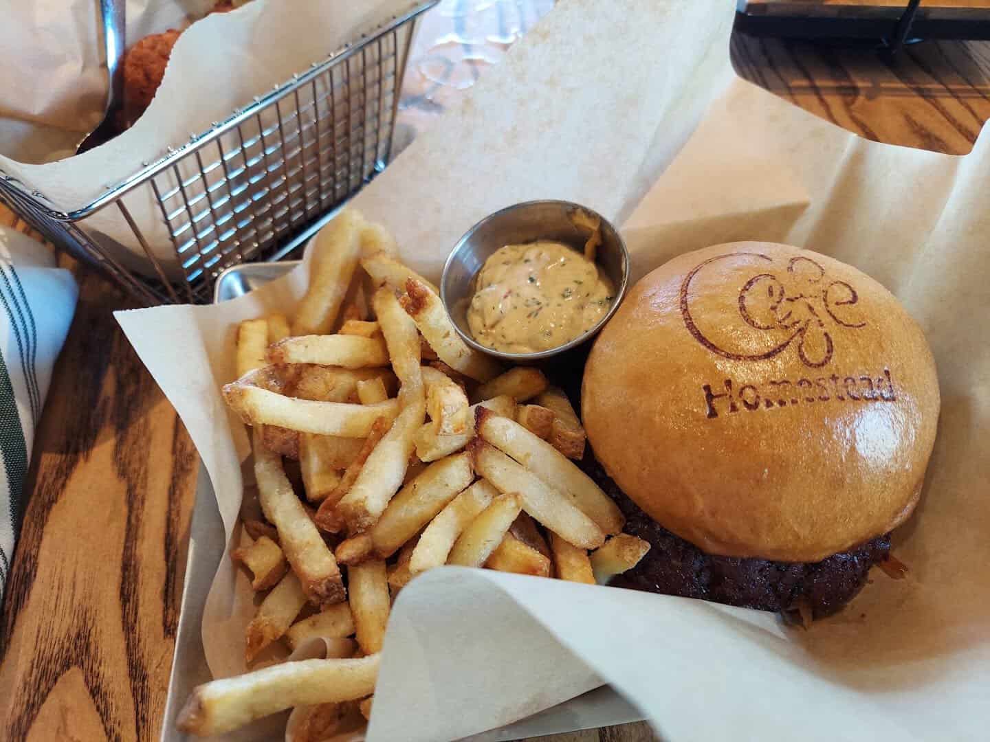 Cowboy coffee burger with a branded bun and fries at Cafe Homestead in Waco, Texas