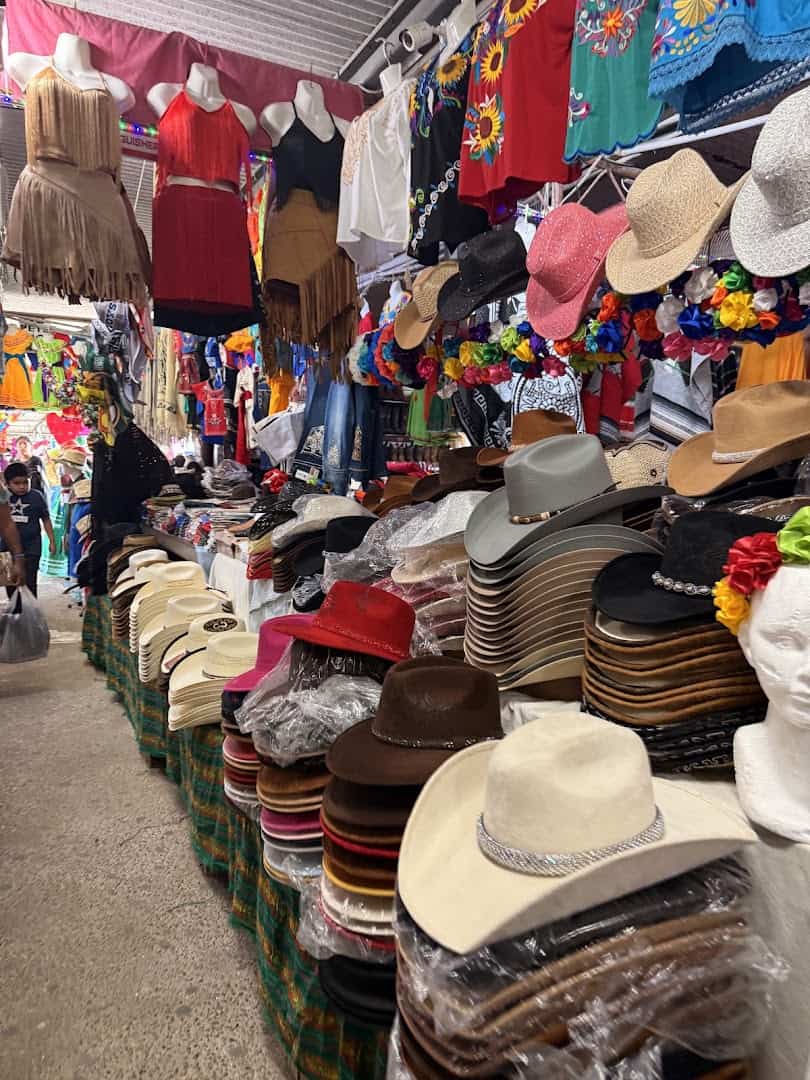 Cowboy hats and goods for sale at a 77 Flea Market vendor stall in Brownsville, Texas