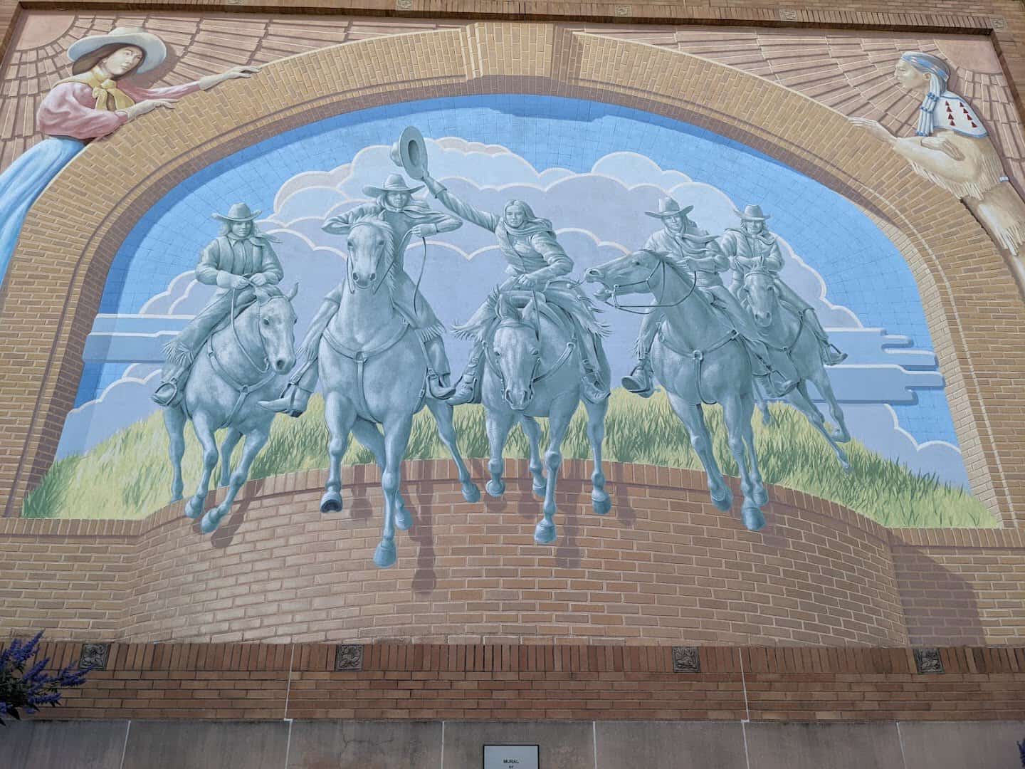 Mural of horseback riders on the brick facade of the National Cowgirl Museum in Fort Worth