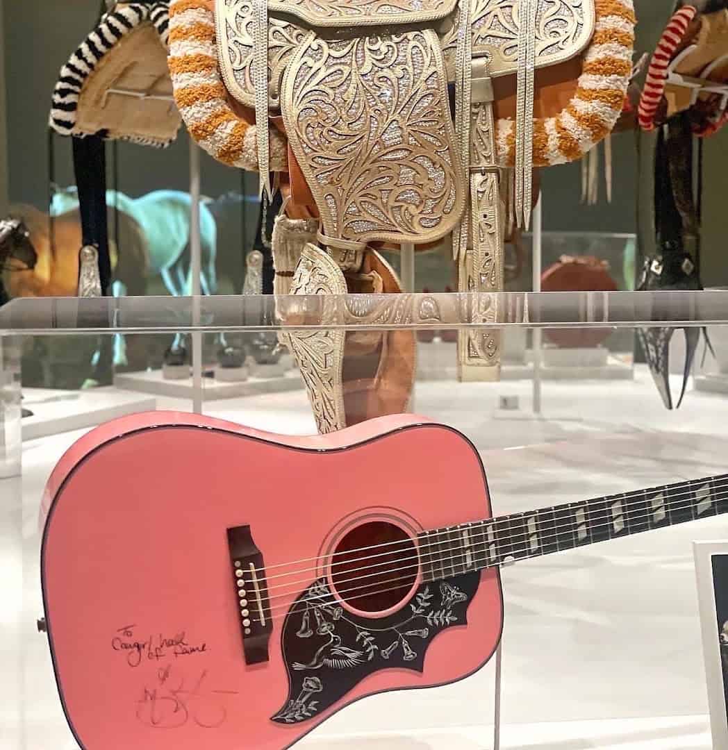 Ornate silver saddle and a signed guitar on display at the National Cowgirl Museum in Fort Worth