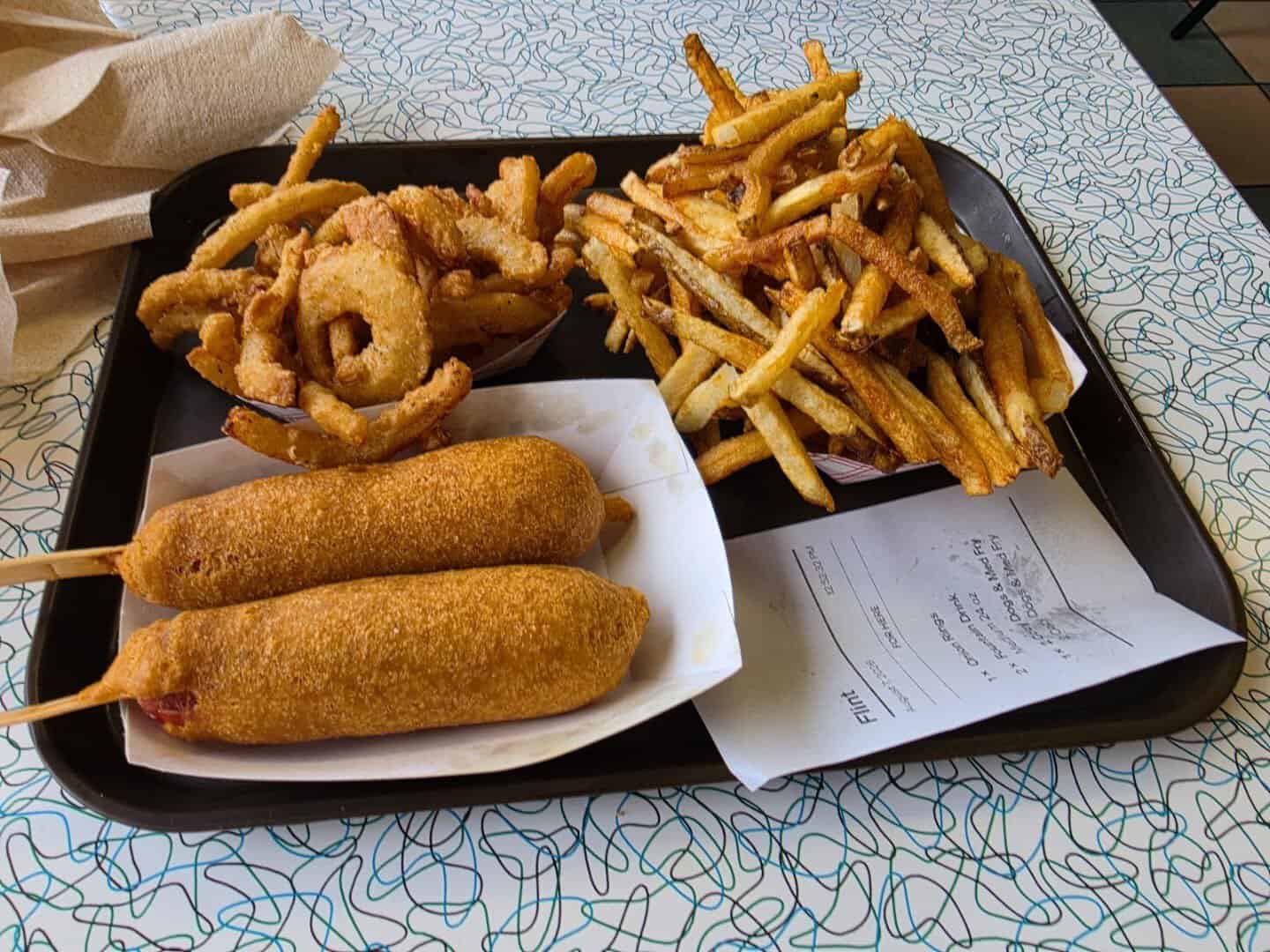 Cozy dogs, onion rings, and fries on a tray at Cozy Dog Drive In in Springfield, Illinois
