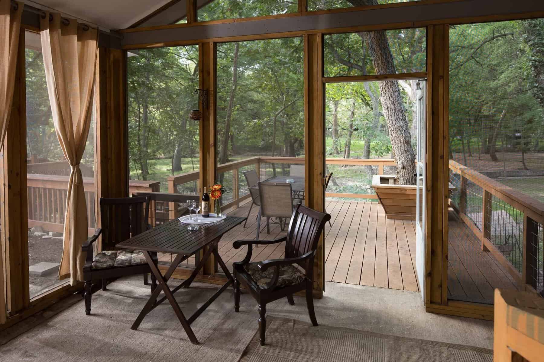 Screened cottage porch overlooking the woods at Cypress Creek Cottages in Wimberley Texas