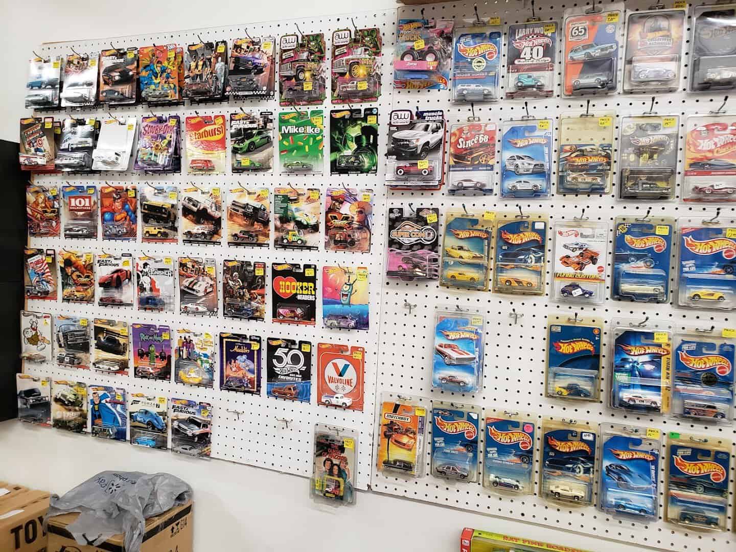 A pegboard wall of packaged diecast cars at a collectibles booth in Cole's flea market, Pearland, Texas