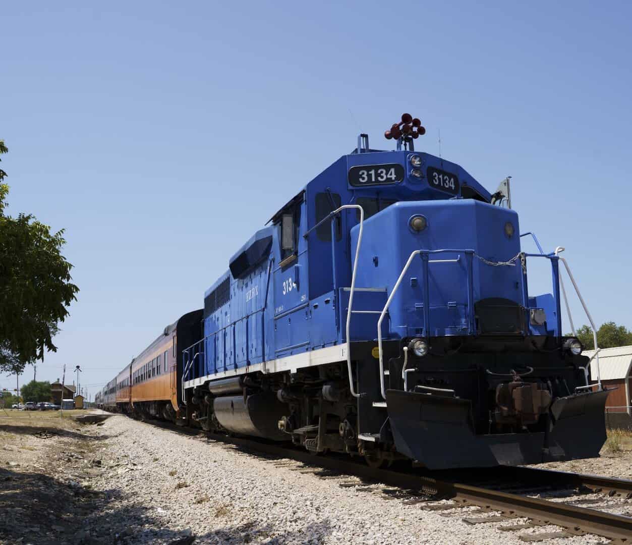 Blue diesel locomotive on the tracks at the Austin Steam Train yard in Cedar Park, Texas