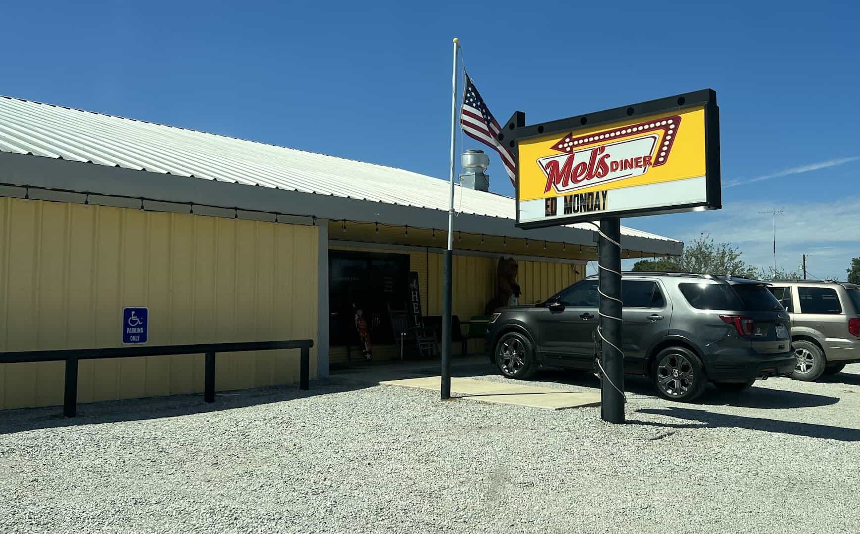 Exterior metal building and sign of Mel's Diner in Mingus, Texas