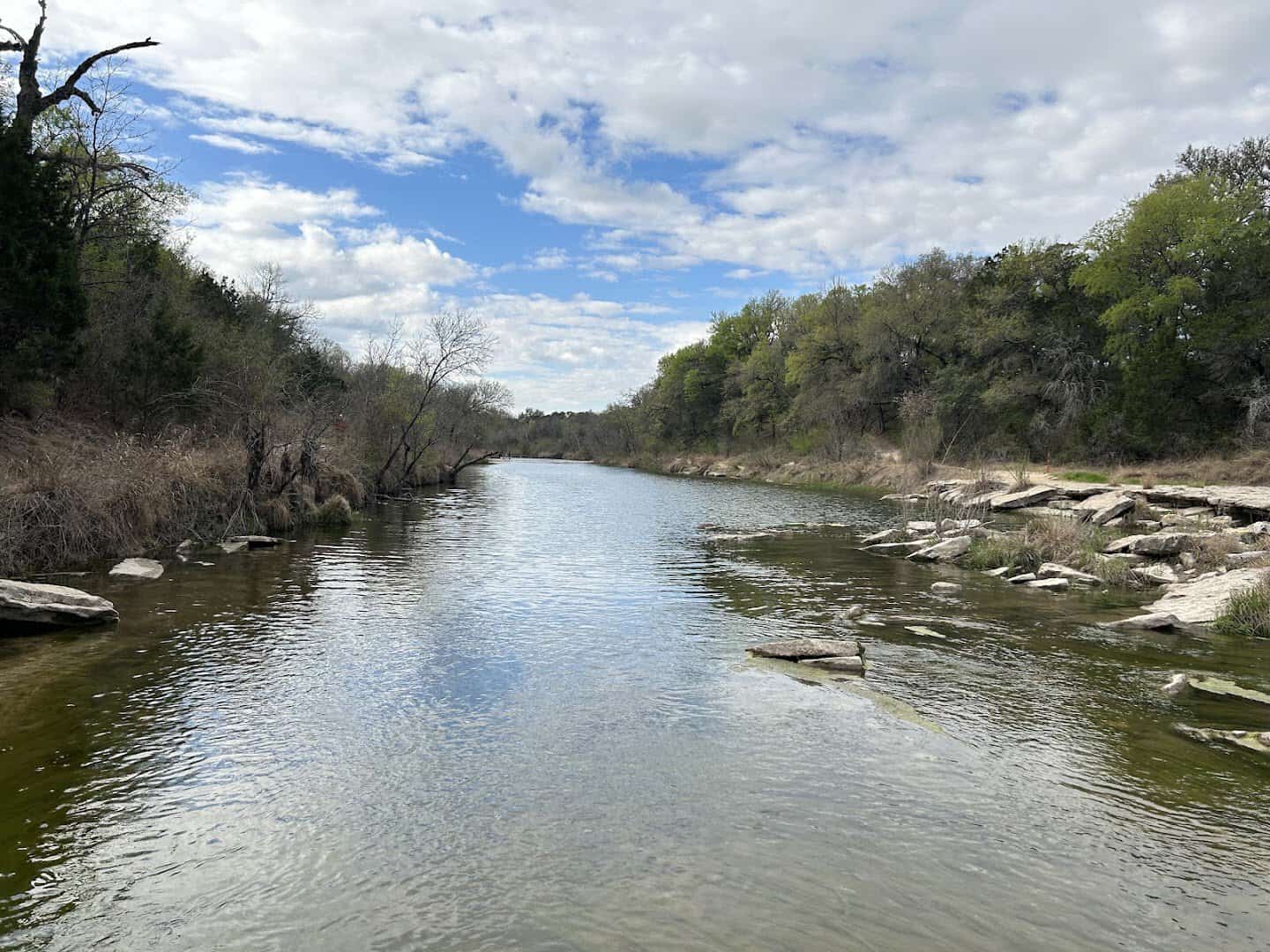 The clear Paluxy River flowing past limestone banks at Dinosaur Valley State Park in Glen Rose, Texas