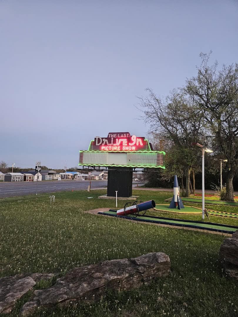 The neon marquee glowing at dusk beside the highway at The Last Drive-In Picture Show in Gatesville, Texas