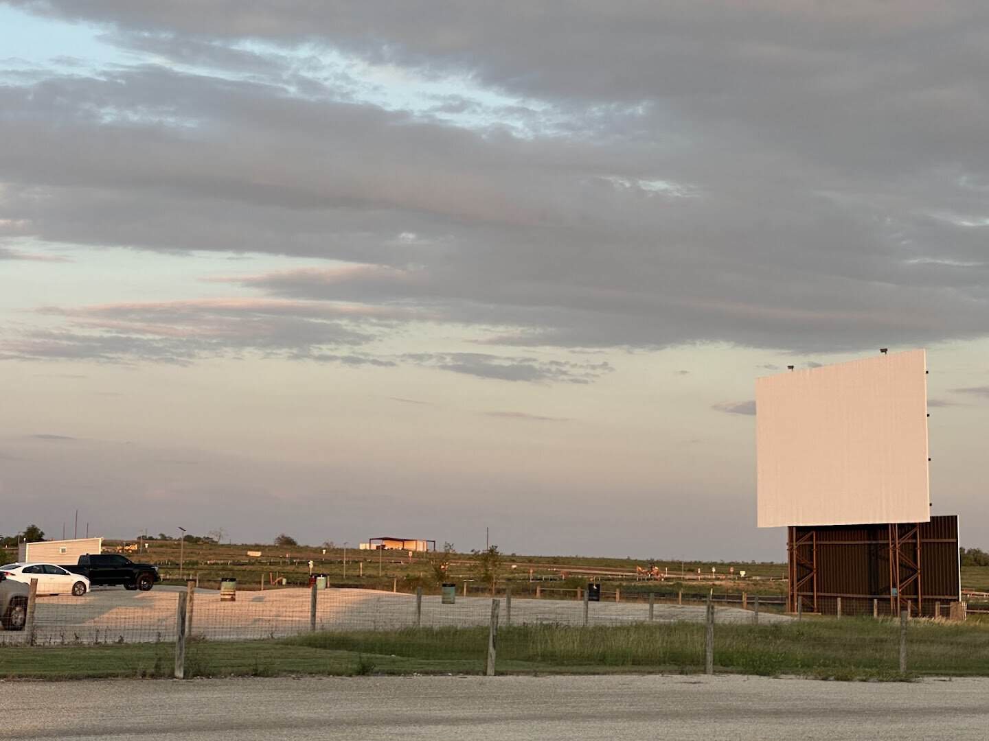 Drive-in movie screen standing in an open field at dusk near New Braunfels, Texas