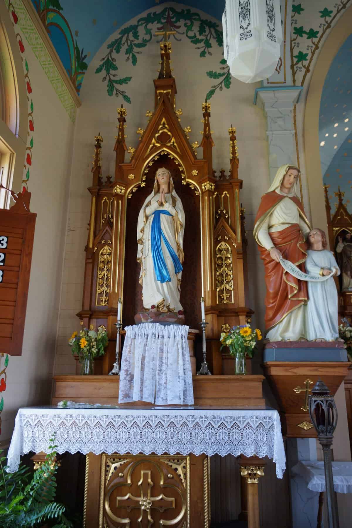 Marian side altar with statues and wildflowers inside the Dubina painted church in Texas
