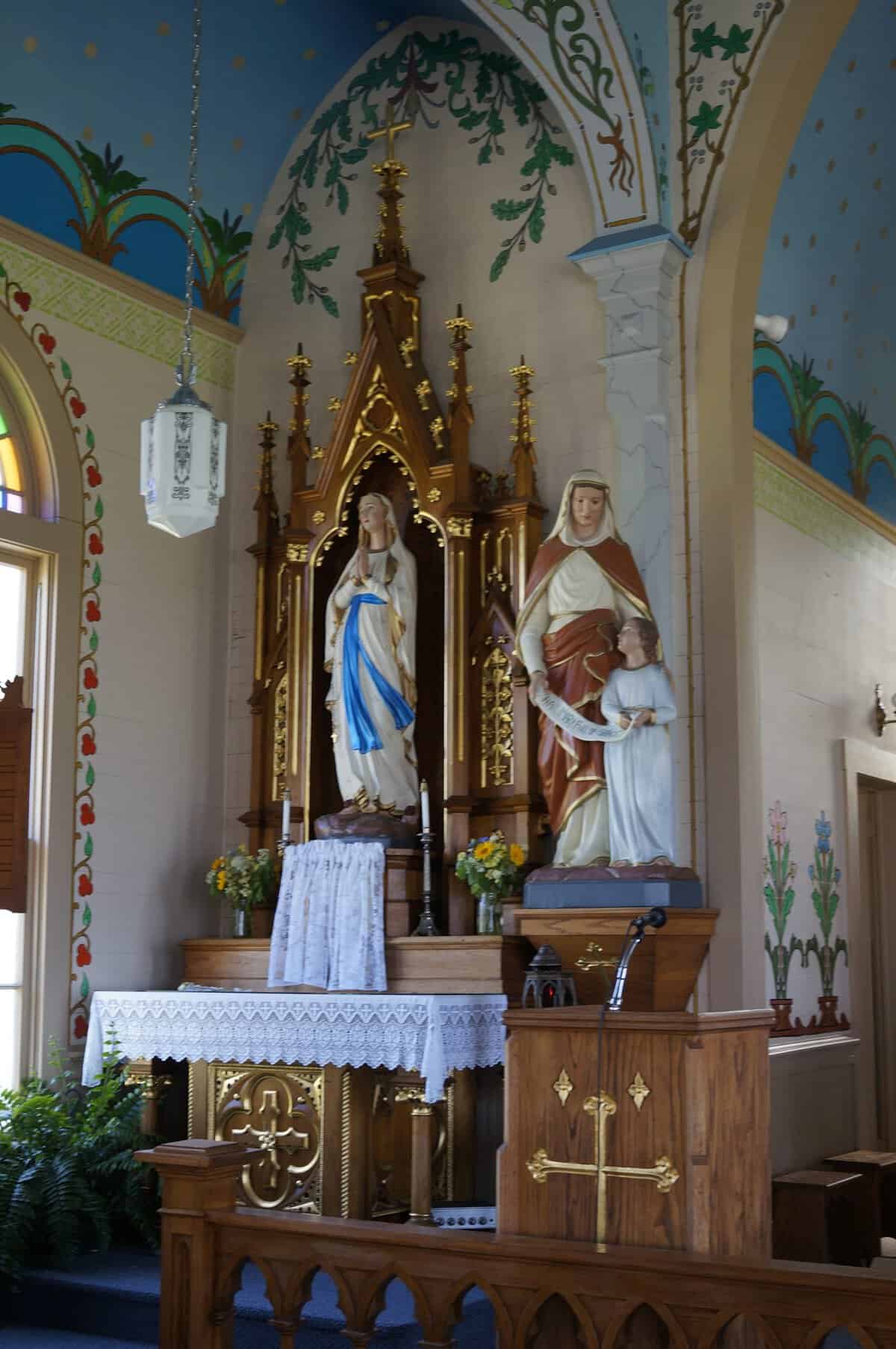 Marian side altar framed by hand-painted arches and greenery in the Dubina painted church, Texas