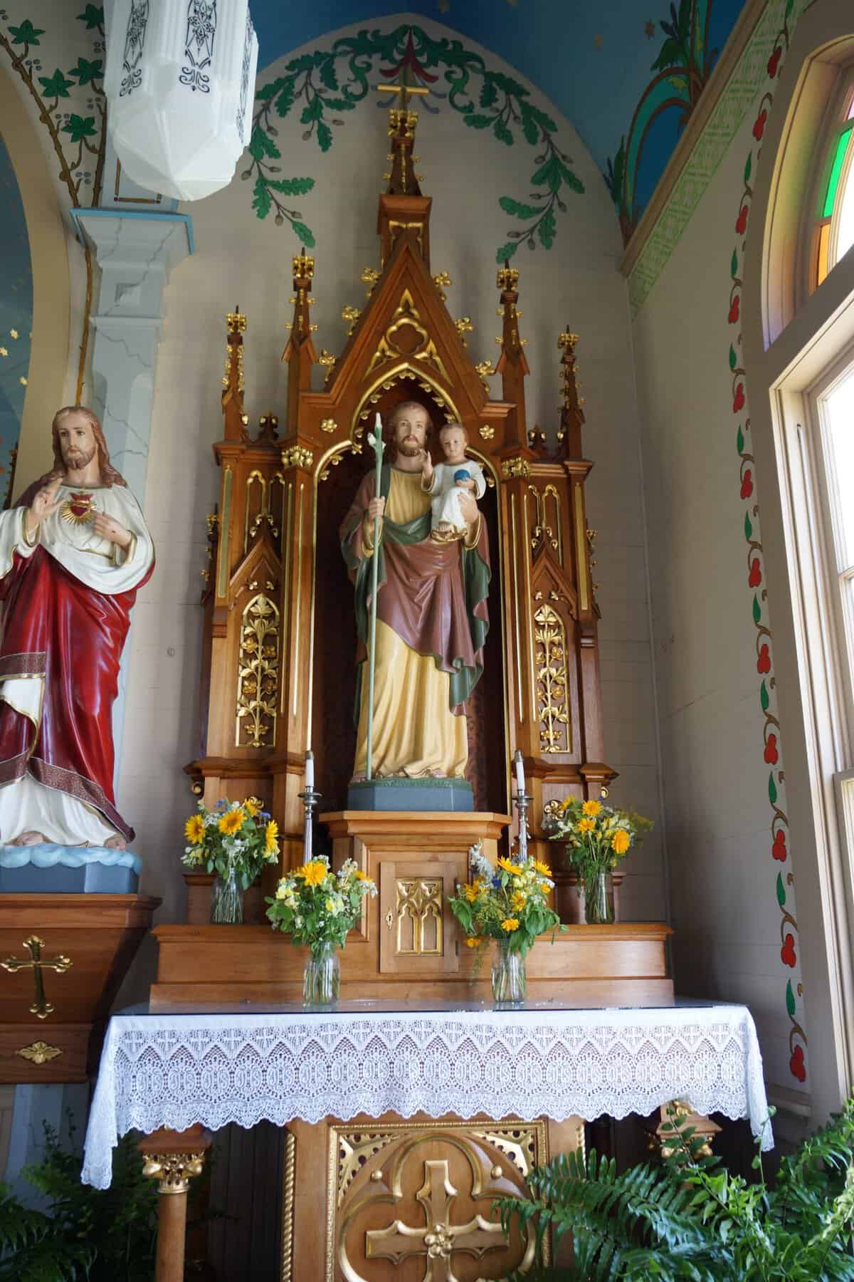 Side altar with statues of Christ and Saint Joseph framed by painted oak leaves in Dubina, Texas