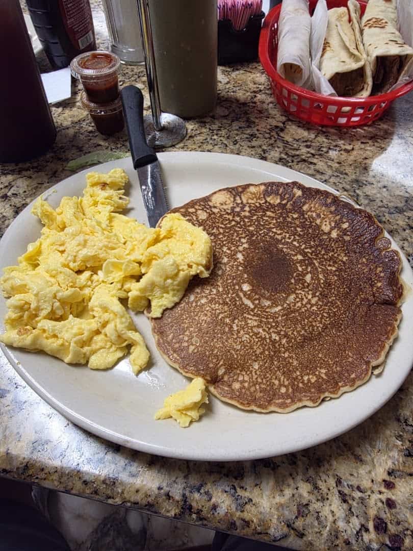 Eggs and pancake with a basket of fresh flour tortillas at Eddie's Taco House