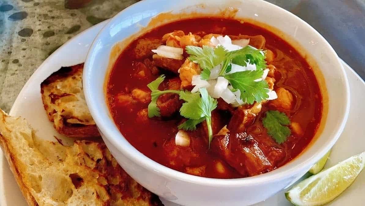 Hearty red pozole with garnishes at El Jacalito in Austin, Texas
