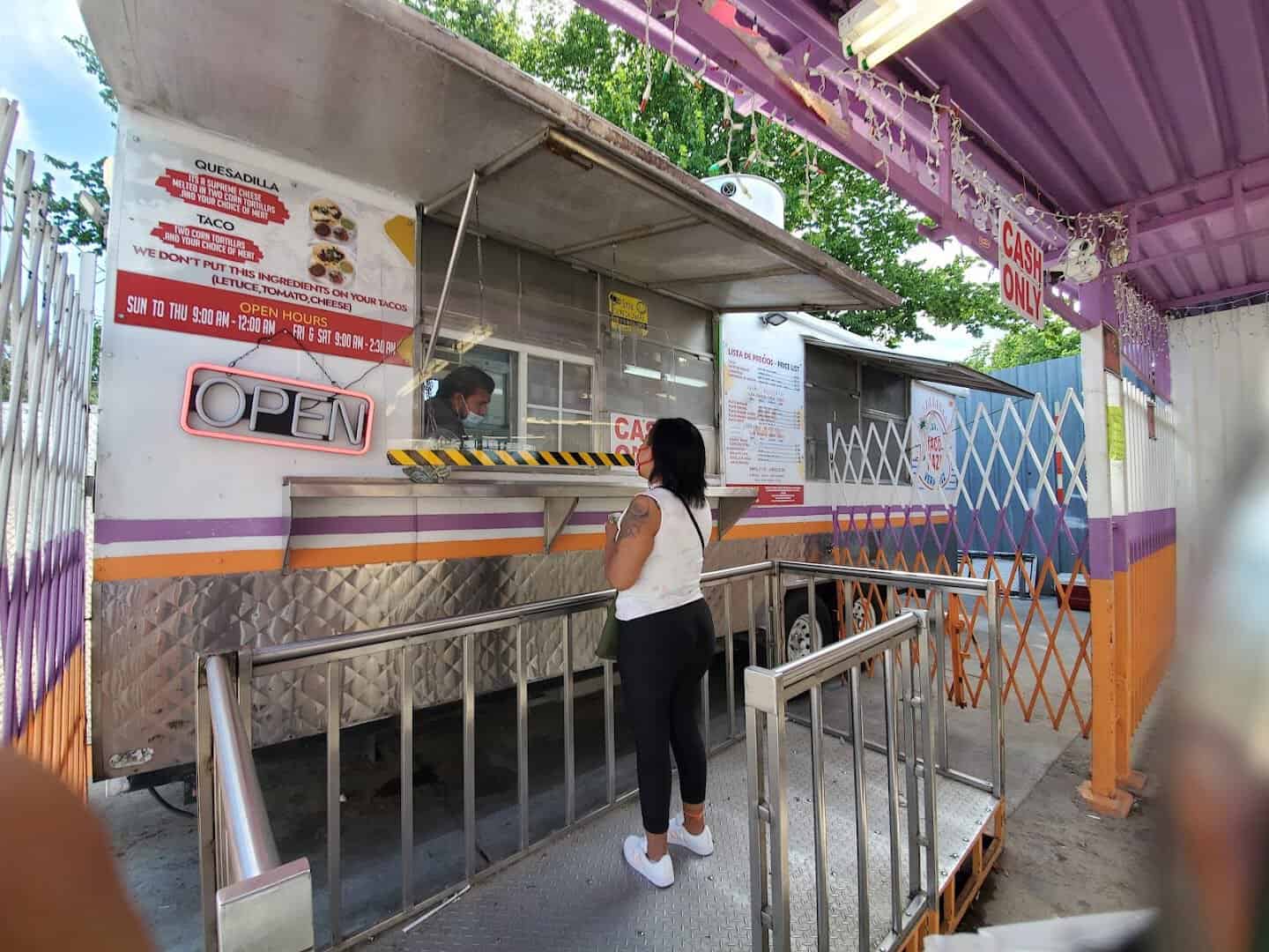 A customer reading the menu at the El Taconazo window in Houston