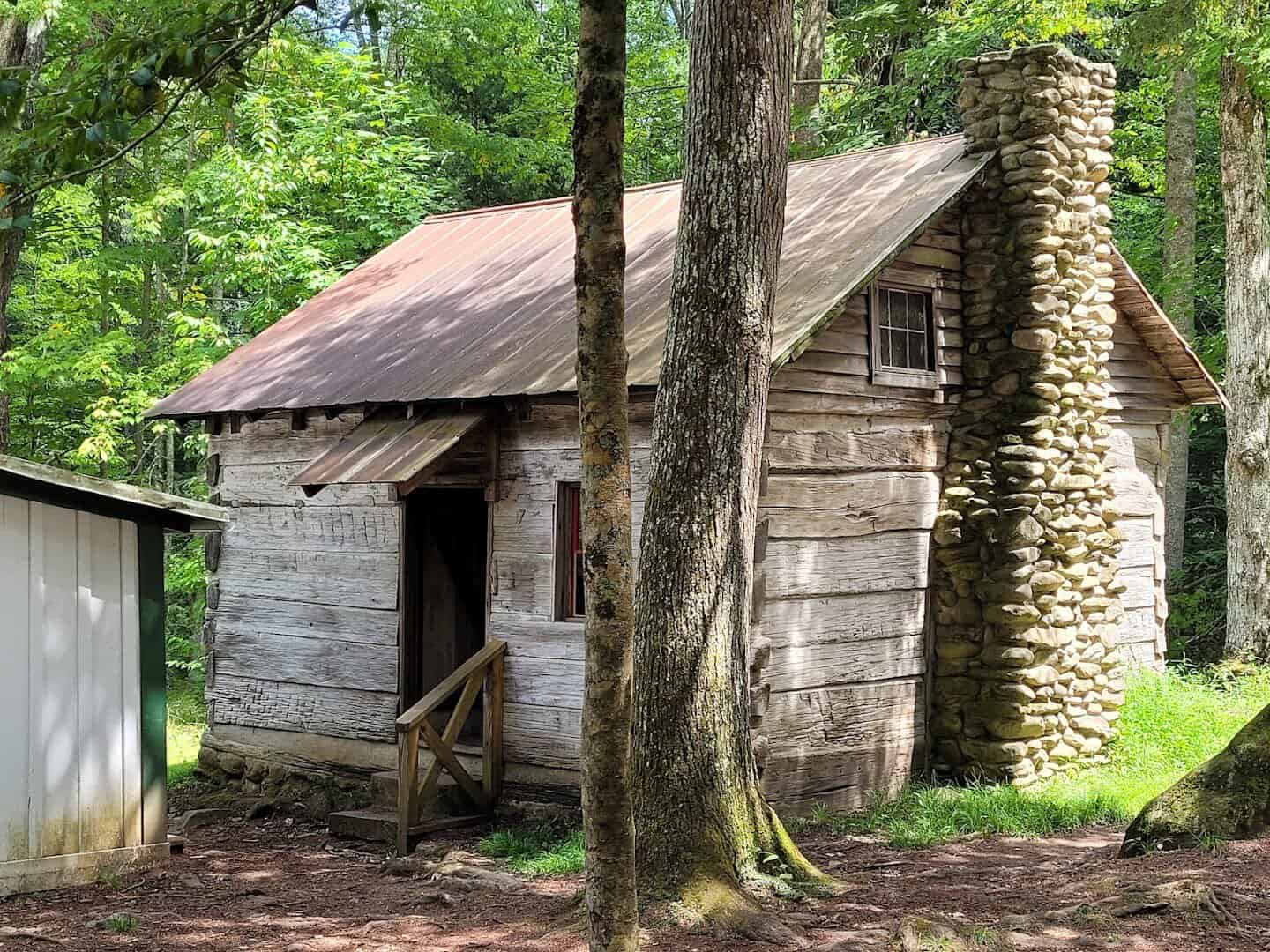 Weathered log cabin with stone chimney at Elkmont ghost town, Tennessee