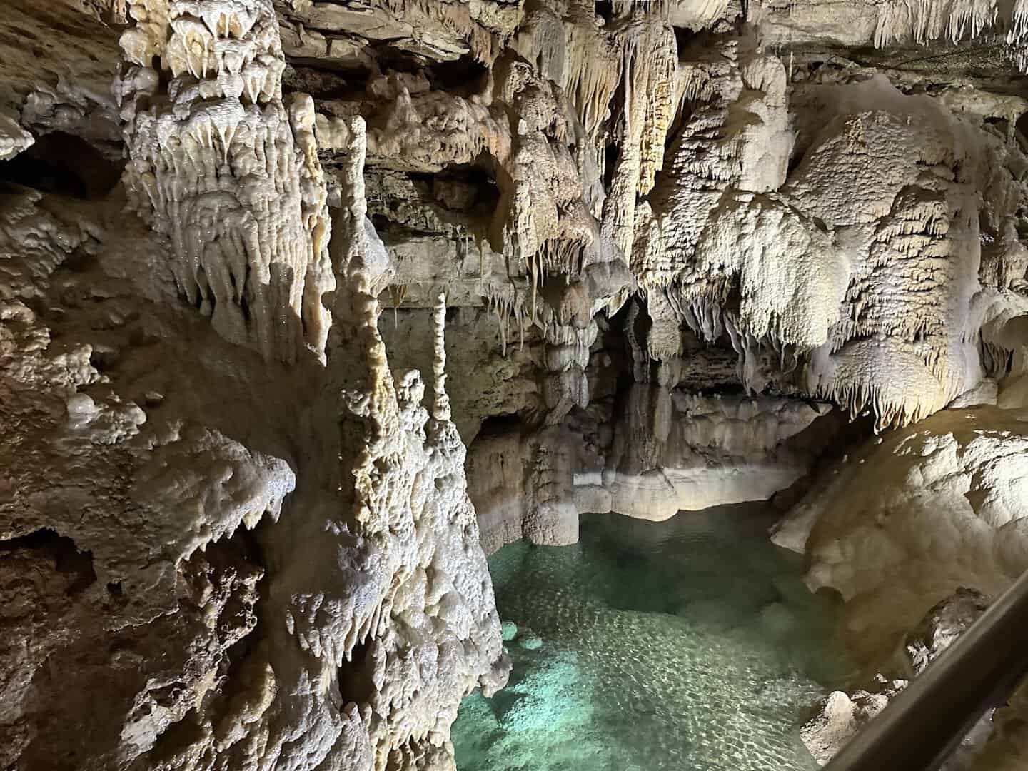 Glowing blue underground pool and cave formations at Natural Bridge Caverns