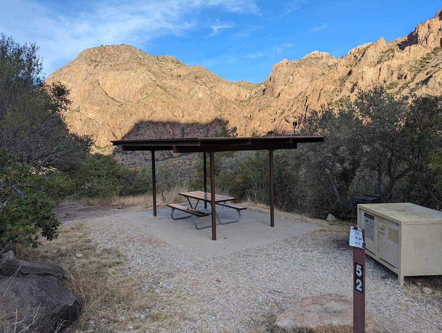 An empty numbered campsite with shade shelter and bear locker at Chisos Basin Campground