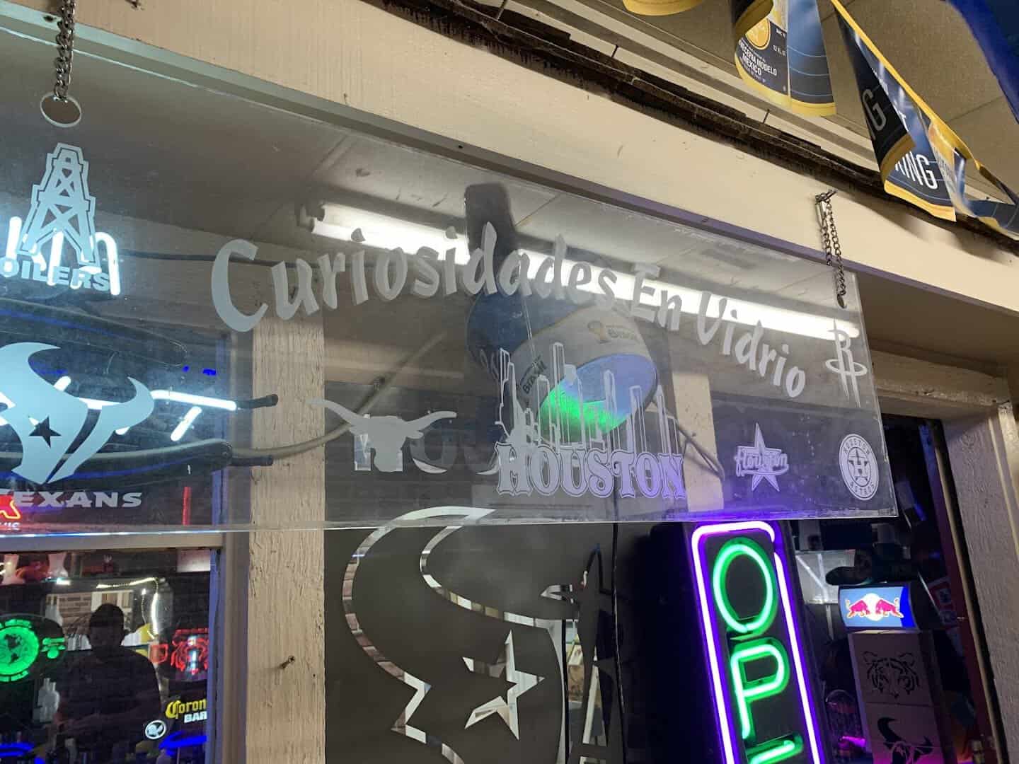 Etched glass signage and a neon open sign at an indoor vendor booth in Cole's Antique Village, Pearland, Texas