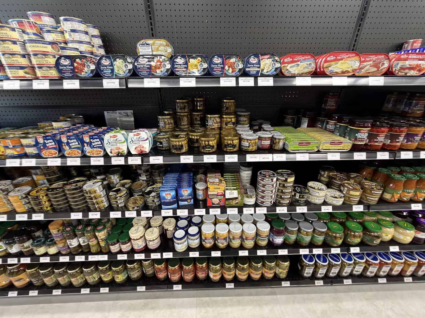Shelves of imported canned fish and pantry jars at Gourmet European Market in Dallas
