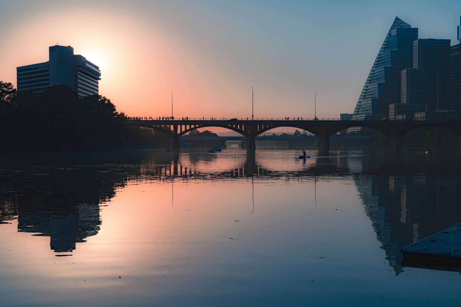 Warm evening light over Lady Bird Lake with the Austin bat bridge in silhouette
