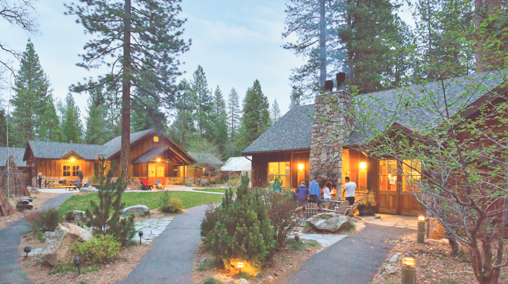 Wood cabins glowing among tall pines at Evergreen Lodge near Yosemite, California
