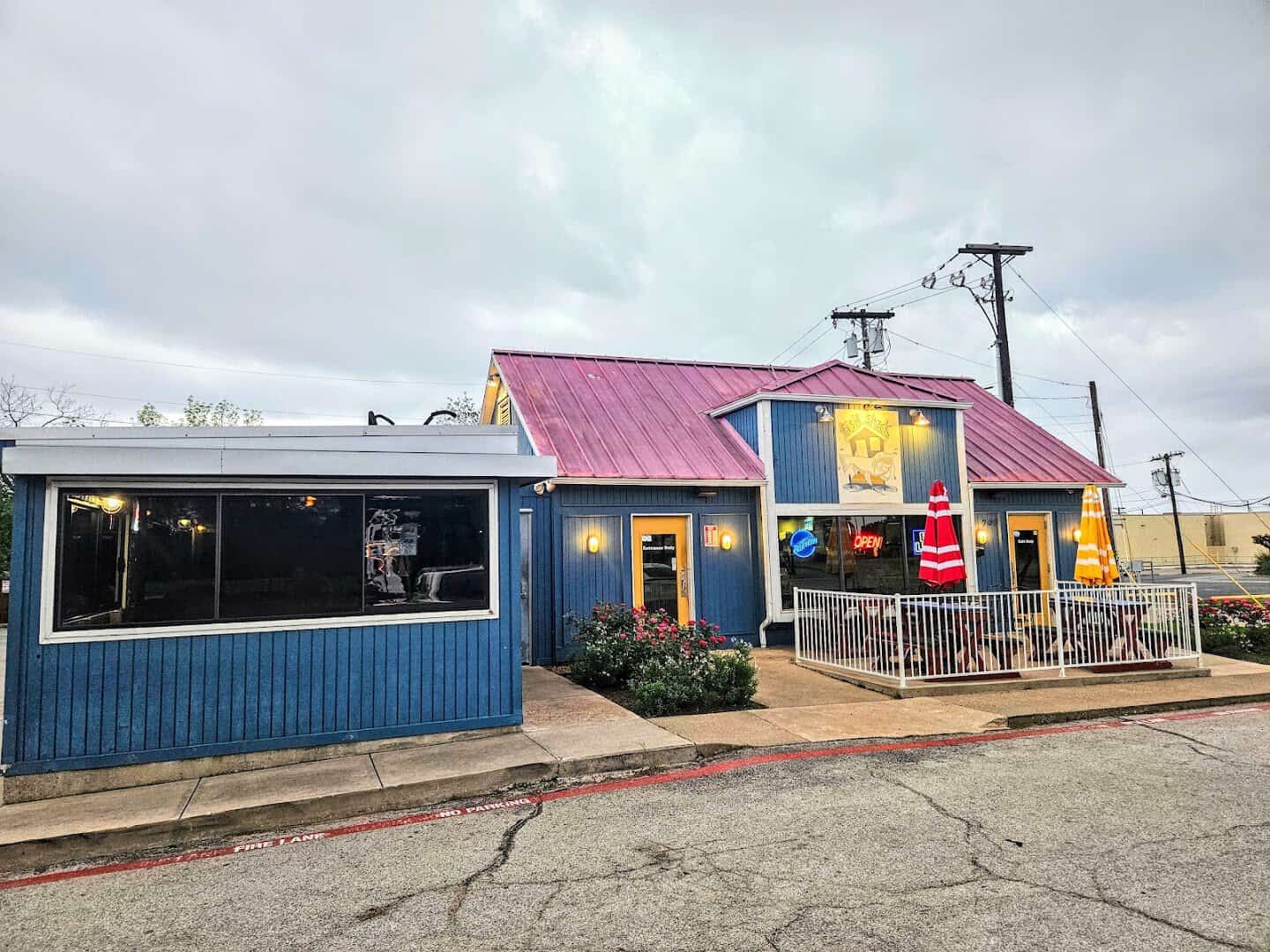 Blue clapboard exterior and patio of Fish Shack in downtown Plano, Texas