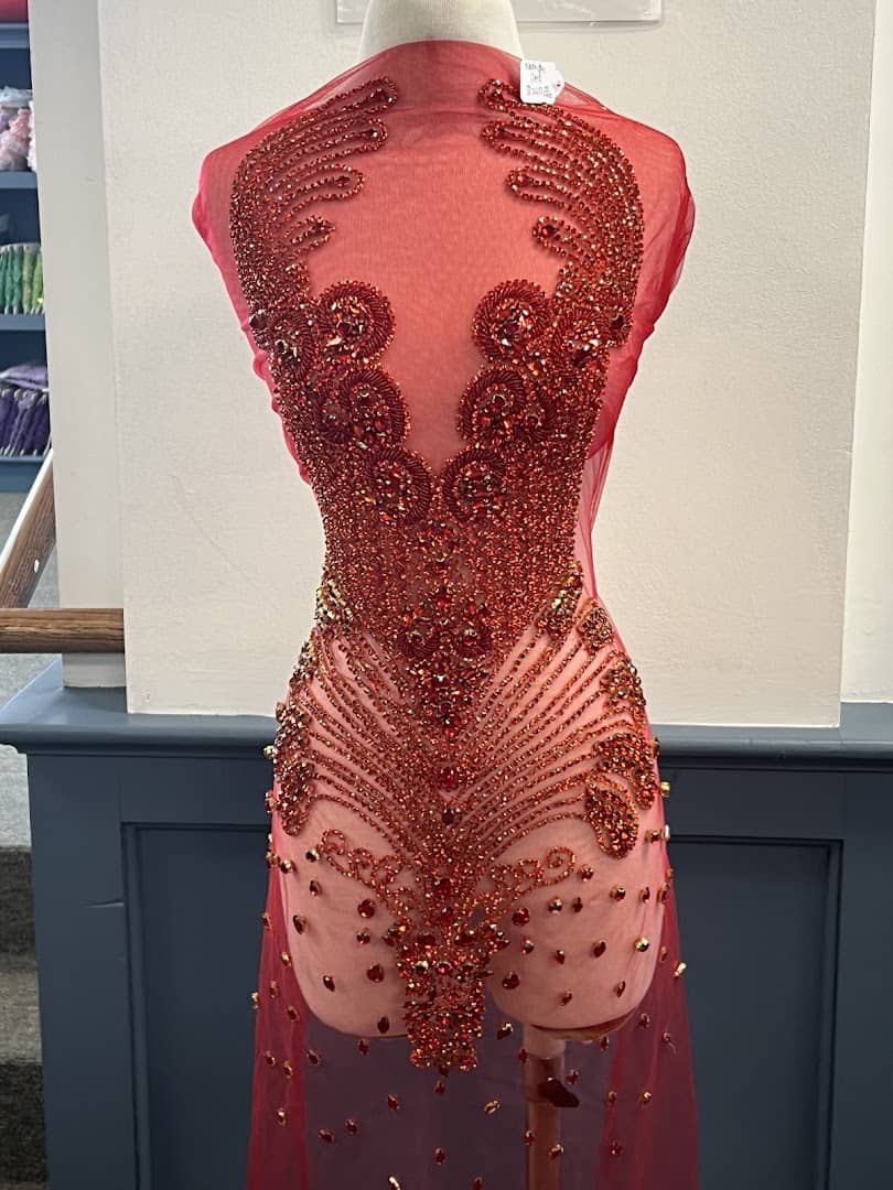 Red beaded formal gown on a dress form at Fabrictopia in Houston