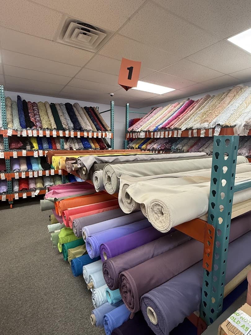 Upright rolls of fabric bolts on warehouse racks at Fabrictopia in Houston